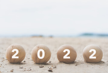 2022 on wood ball on the beach. travel on Happy New Year. relaxing vacation. Good life and new...