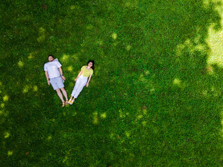 smiling couple laying down on green grass