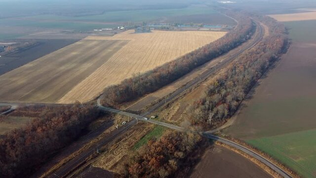 Panoramic View of Railroad Crossing Between Trees Fields Autumn Day Aerial Drone