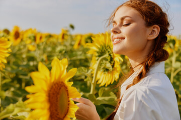 Cheerful woman in a sunflower field landscape nature sun agriculture