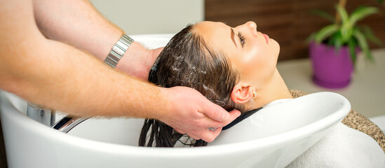 Obraz na płótnie Canvas Beautiful caucasian woman washing hair in a beauty salon