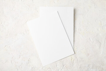 Two white invitation card mockup on light stone background 5x7 ratio