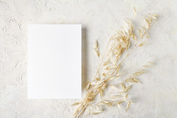 White invitation card mockup with a dry grass decoration. 5x7 ratio