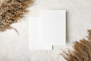 Two white invitation card mockup with a pampas grass decoration 5x7