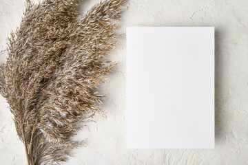 White invitation card mockup with a pampas grass decoration. 5x7 ratio