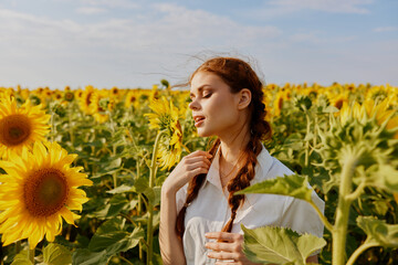 woman with closed eyes in a field of sunflowers with pigtails nature landscape