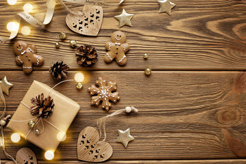 christmas card with gingerbread cookies, gift box and christmas ornaments on wooden background
