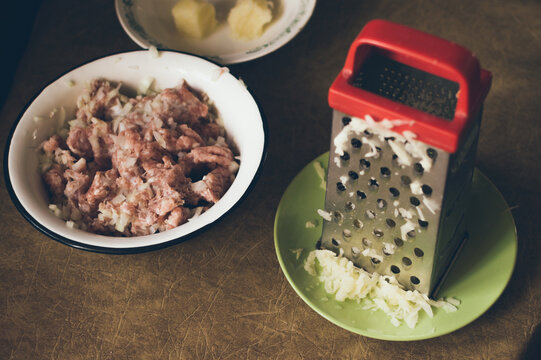 Cooking minced meat. Grating potatoes on grater