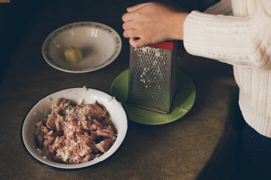 Cooking minced meat. Grating potatoes on grater
