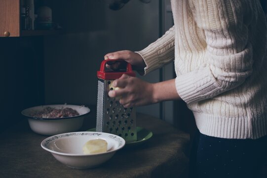 Cooking minced meat. Grating potatoes on grater