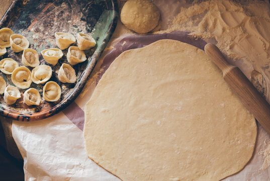 Dumplings on oval tray and rolled dough, top view