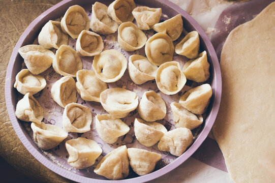 Dumplings on round tray and rolled dough, top view