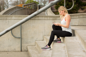 Attrractive woman in workout gear texting