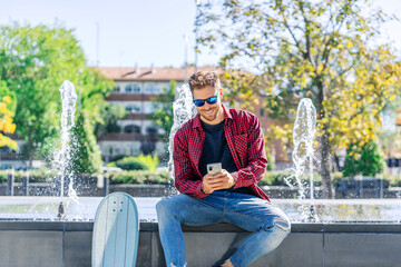 young skater sending an email from his smartphone