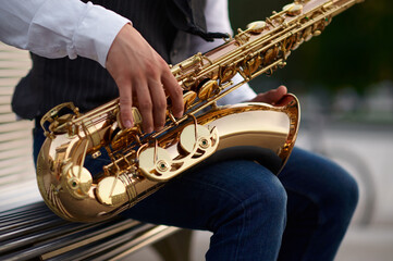 Obraz premium Saxophonist plays melody at the stairs on street