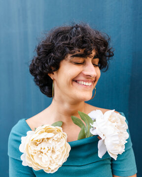 Happy woman with lush blooming peonies