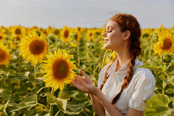 Woman in white dress with pigtails in a field of sunflowers joy nature