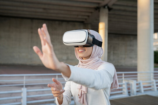 Arab woman in VR headset on embankment