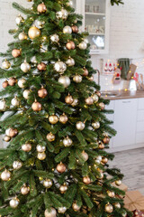 The tree is decorated with colorful toys and a garland. Close-up photo in warm colors. Christmas and New Year atmosphere