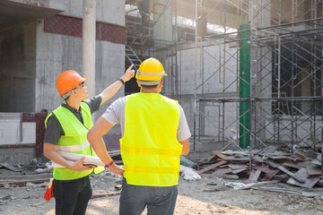 Engineer discussing with foreman about project in building construction site.