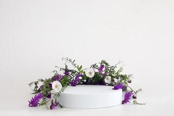 White podium on the white background with flowers. Podium for product, cosmetic presentation....