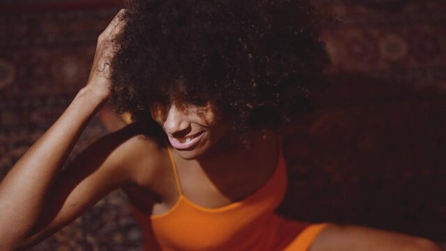 Woman With Afro Hair In Orange Dress Smiling To Camera