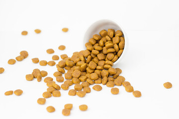 Pet food on a white background. Food is scattered around.