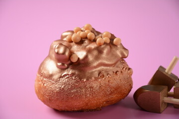 Donuts(sufgania) and dreidal - Jewish holiday Hanukkah symbols. Fresh donuts for Hanukkah celebration.