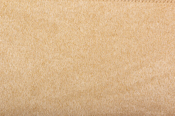 Fototapeta na wymiar Light beige matte background of suede fabric, closeup. Beige suede soft leather as texture background
