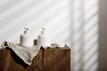 Soap and lotion white ceramic dispensers with pump, organic linen towel and dry shampoo on solid...