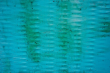 A sheet of grunge metal painted blue. Faded and weathered background. Ribbed pattern surface