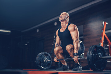 Fototapeta na wymiar Adult Bodybuilder doing heavy deadlift exercise with weight while in gym. Bodybuilding concept 