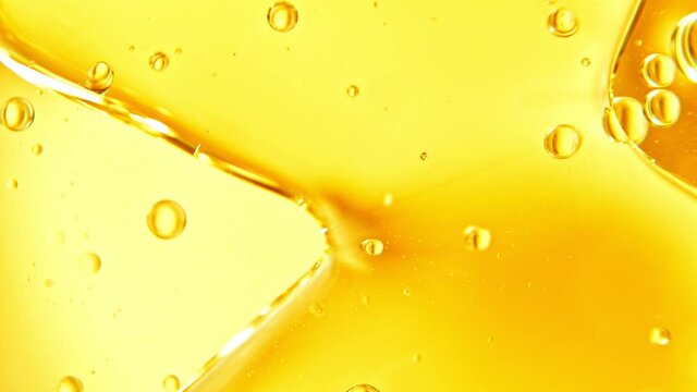 Super Slow Motion Shot of Moving Oil Bubbles on Golden Background at 1000fps.