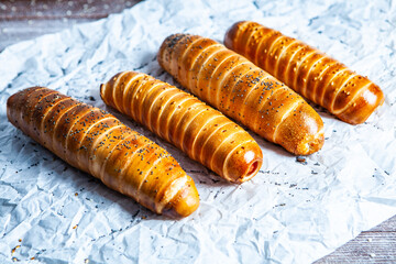 Fresh tasty sausage rolls on plate. fresh sausage in dough on wood background.
