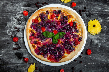 Sweet pizza with pineapple, currant and strawberries.