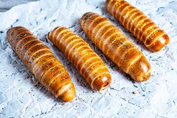 Fresh tasty sausage rolls on plate. fresh sausage in dough on wood background.