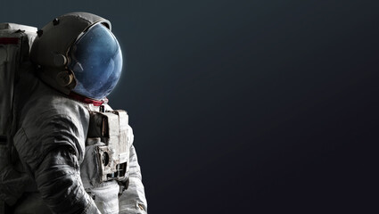 Astronaut isolated on dark background. Spaceman with space and stars in helmet. Creative sci-fi space wallpaper. Elements of this image furnished by NASA