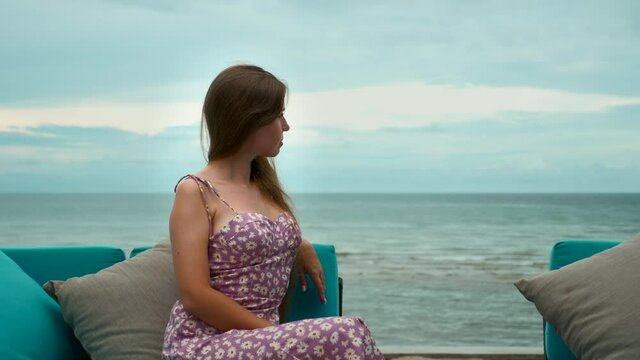 Attractive lonely, thoughtful woman sitting alone on beach, sad, thinking of future, dreaming of love. Unhappy female, loneliness and depression, worried looking at sea