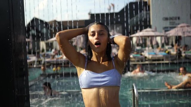 Beautiful Girl In Swimwear Showering Under Water At Resort Beach.