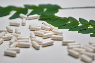 Many white capsule pills on a colorful background. Health supplements and medicines