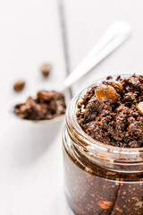 Body scrub of ground coffee on wooden table background