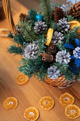 Christmas basket with cones and fir branches, vanilla sticks and orange