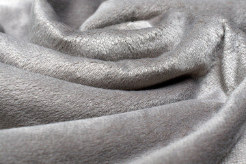 faux fur fabric. Gray plaid with folds of soft artificial fabric close up.