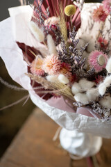 Bouquet of dried flowers pink white on a wooden background