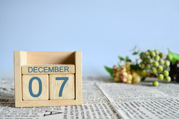 December 7, Calendar cover design with number cube with fruit on newspaper fabric and blue...
