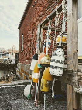 Old Fishing And Lobster Buoys With Brick Building In Background