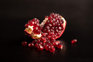 pomegranate, pomegranate seeds are scattered on a dark background