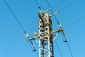 High voltage electricity pole against the blue sky.