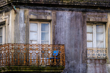 A blue office chair on an old balcony of an abandoned house.