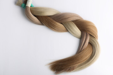 Women's hair sections for extension braided in tail,on the white background. © Bidzilya